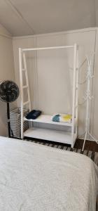 1 dormitorio con litera blanca y escalera en Lovely Cabin with private garden, en Noordhoek