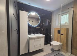 a bathroom with a sink and a toilet and a mirror at EIRA Apartament - Self check-in in Szklarska Poręba
