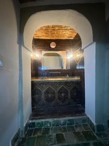 a bathroom with a mirror and a tile floor at Kasbah Ziwana - Guesthouse in Zagora