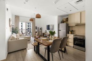 a kitchen and living room with a table and chairs at Waterfront Yas 1BR near F1 & Ticket Savings in Abu Dhabi