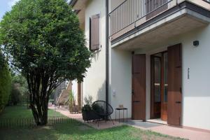 a building with a bench next to a tree at GardaEssence in Peschiera del Garda