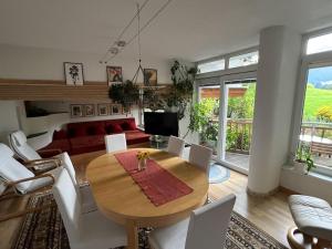 a living room with a wooden table and white chairs at Ferienwohnung Christ in Grinzens