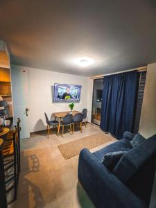 a living room with a blue couch and a table at Moderno apartamento cerca de las mejores clínicas de la ciudad in Floridablanca