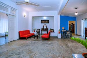 een woonkamer met rode stoelen en een tafel bij Villa Eva in Matara