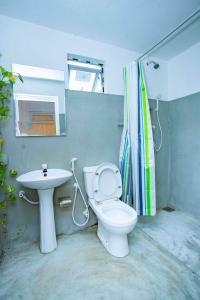 een badkamer met een wit toilet en een wastafel bij Villa Eva in Matara
