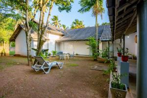 een tuin met stoelen en een huis met palmbomen bij Villa Eva in Matara