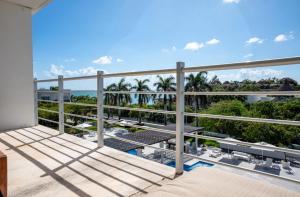 d'un balcon avec vue sur l'océan et les palmiers. dans l'établissement Magia beachside condos, à Playa del Carmen