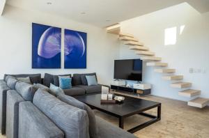 un salon avec un canapé et un escalier dans l'établissement Magia beachside condos, à Playa del Carmen