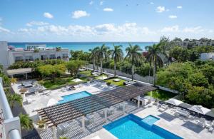 une vue aérienne d'un complexe hôtelier avec piscine et l'océan dans l'établissement Magia beachside condos, à Playa del Carmen