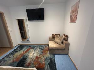 sala de estar con silla y TV de pantalla plana en AL Bela Vista, en Paredes de Coura