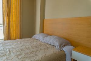 a bedroom with a bed with a wooden headboard and a window at Hospedaje Andina H&M in Tacna +3 photos