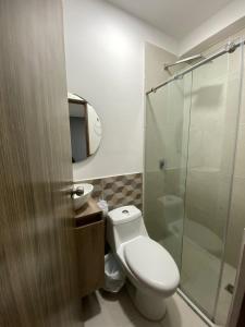 a bathroom with a toilet and a glass shower at Hotel pasarela real cali in Cali +32 photos