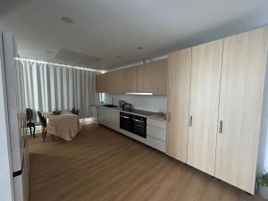 Una cocina con gabinetes de madera y una mesa en ella. en AL Bela Vista, en Paredes de Coura