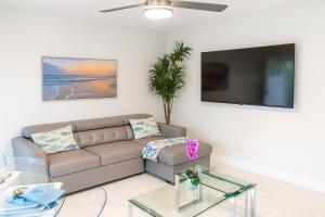 Una sala de estar con un sofá y un televisor de pantalla plana. en Steps from Airport Hot Tub Bbq Boat Slip, en Dania Beach
