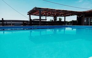 a large blue swimming pool with a pavilion at Quinta Cavaluz in Poceirão