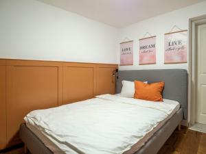 a bedroom with a bed with white sheets and orange pillows at Schiffmeisterapartment Melk - Design trifft Geschichte - Herbstspecial 3 Nächte bleiben 2 bezahlen in Melk