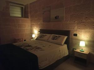 a bedroom with a bed and two lamps on tables at CIVICO 33 in Bisceglie