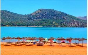 a beach with a bunch of umbrellas and chairs at CASA FILO VISTAS MONTAÑa in Rute