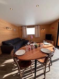 Le Zelfée appartement de 4 personnes à Albiez-Montrond في ألبيز-مونتروند: طاولة وكراسي خشبية في غرفة المعيشة