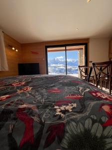 Le Zelfée appartement de 4 personnes à Albiez-Montrond في ألبيز-مونتروند: غرفة نوم بسرير كبير مع نافذة كبيرة