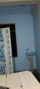 a bathroom with a sink and a blue wall at Jongki khun stay inn in Mawlynnong