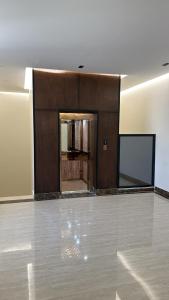 an empty room with a large wooden wall and a screen at شقة غرفة وصالة اطلالة على البرج in Al Kharj