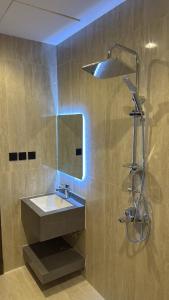 a bathroom with a sink and a shower with a light at شقة غرفة وصالة اطلالة على البرج in Al Kharj