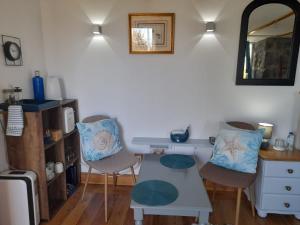 ein Zimmer mit zwei Stühlen, einem Tisch und einem Schreibtisch in der Unterkunft Lost in Thyme in Lajes do Pico