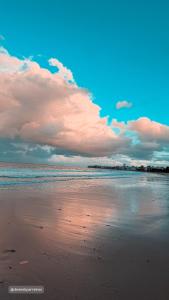 a beach with a cloudy sky and the ocean at Refúgio no Bessa in João Pessoa +16 photos