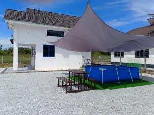 a tent in front of a building with a table at De'5 Tiny House , Besut in Kampong Kubang Bemban