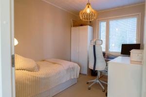 een slaapkamer met een bed, een bureau en een stoel bij Villa Valaja in Rovaniemi