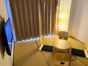 Habitación pequeña con mesa y TV. en Base203, en Kurume