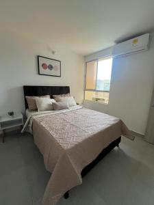 a bedroom with a large bed and a window at Apartamento Cartagena Moderno y Comodo in Manzanillo del Mar