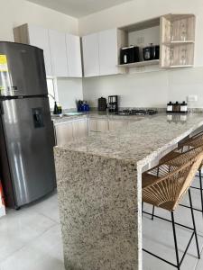 a kitchen with a granite counter top and a refrigerator at Apartamento Cartagena Moderno y Comodo in Manzanillo del Mar