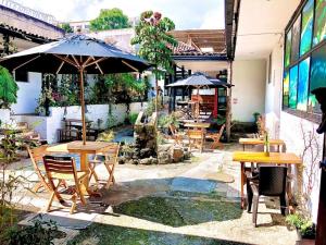 a patio with tables and chairs and an umbrella at El Yarumo Hostel in Bogotá