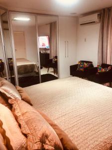 a hotel room with a bed and a television at Casarão da Brisa in Ilha do Tatu