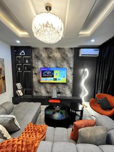 een woonkamer met een bank en een tv bij Pat Luxury Apartments in Uyo