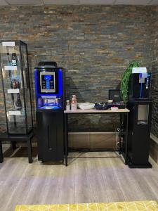 アンネヴィルにあるEnzo Hôtels Diane - Logis Amnévilleのテーブルの横に置かれた券売機 テーブルの横に置かれた券売機