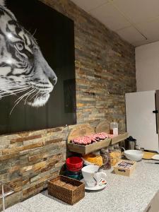 アンネヴィルにあるEnzo Hôtels Diane - Logis Amnévilleの壁に虎の絵が飾られたテーブル