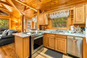 una cucina con mobili in legno ed elettrodomestici in acciaio in una cabina di Briar Brook - Private Smoky Mountain Luxury Log Home with 2 Fireplaces, Hot Tub & Community Pool a Sevierville