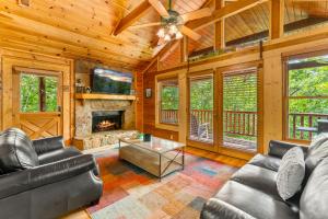 un soggiorno con mobili in pelle e un camino di Briar Brook - Private Smoky Mountain Luxury Log Home with 2 Fireplaces, Hot Tub & Community Pool a Sevierville