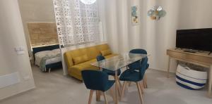 a living room with a yellow couch and a table and chairs at Casetta Giardinetto in Altavilla Milicia