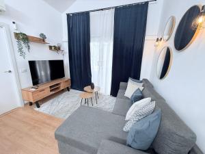 a living room with a gray couch and a television at HDFM Collection - Bungalow Playa del Inglés in Playa del Ingles +26 photos