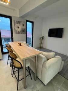 a dining room with a table and a couch at Alia Residence in Buzau