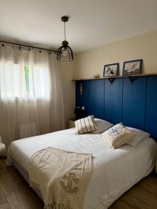 a bedroom with a large bed with a blue headboard at Le Clos Es Rio in Plourhan