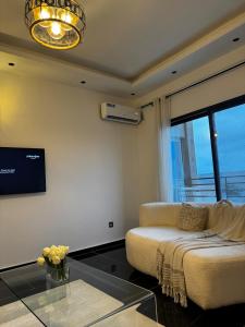 a living room with a couch and a glass table at Sublime appartement à Bonamoussadi in Douala