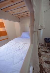 アスワンにあるPajama Hostelの木製天井の客室の白いベッド1台分です。