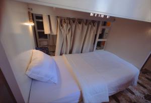 a bedroom with a white bed and a window at Pajama Hostel Nile View in Aswan +6 photos