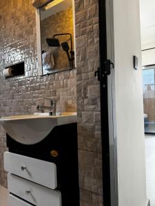 a bathroom with a sink and a mirror at Sublime appartement à Bonamoussadi in Douala