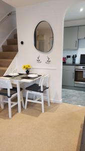 einen weißen Tisch und Stühle in einer Küche mit Spiegel in der Unterkunft Cosy 1 bedroom apartment near Woodstock and Oxford in Kidlington